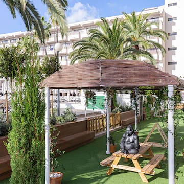 a wooden bench and a gazebo in a courtyard