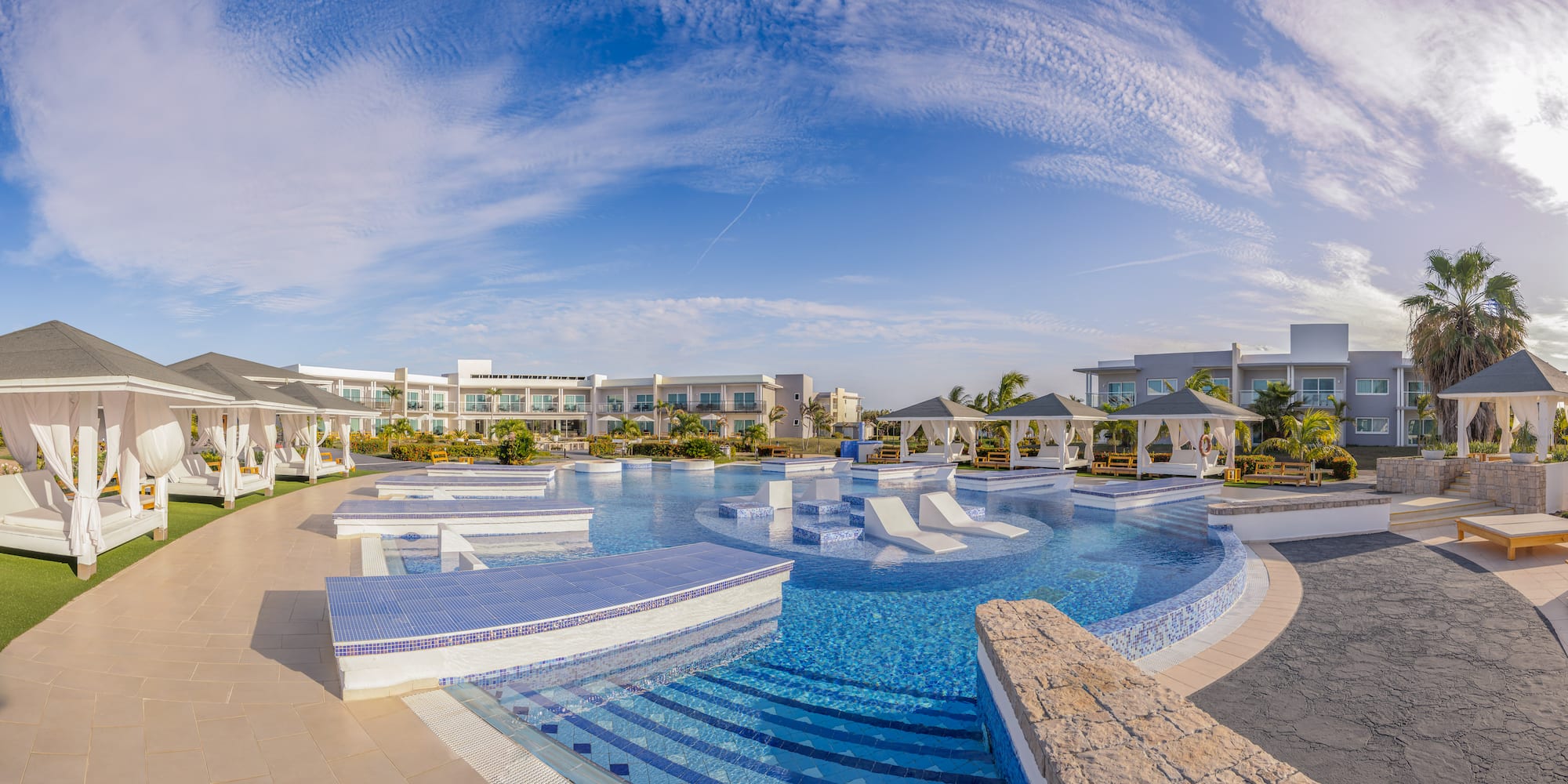 a pool with a deck and chairs in the middle of it