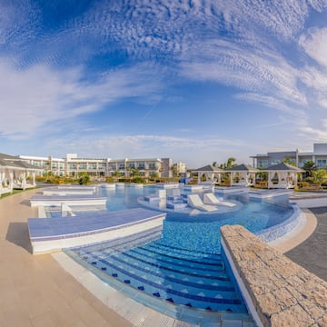 a pool with a deck and chairs in the middle of it