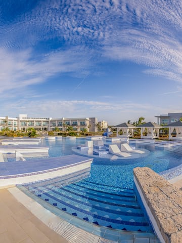 a pool with a deck and chairs in the middle of it