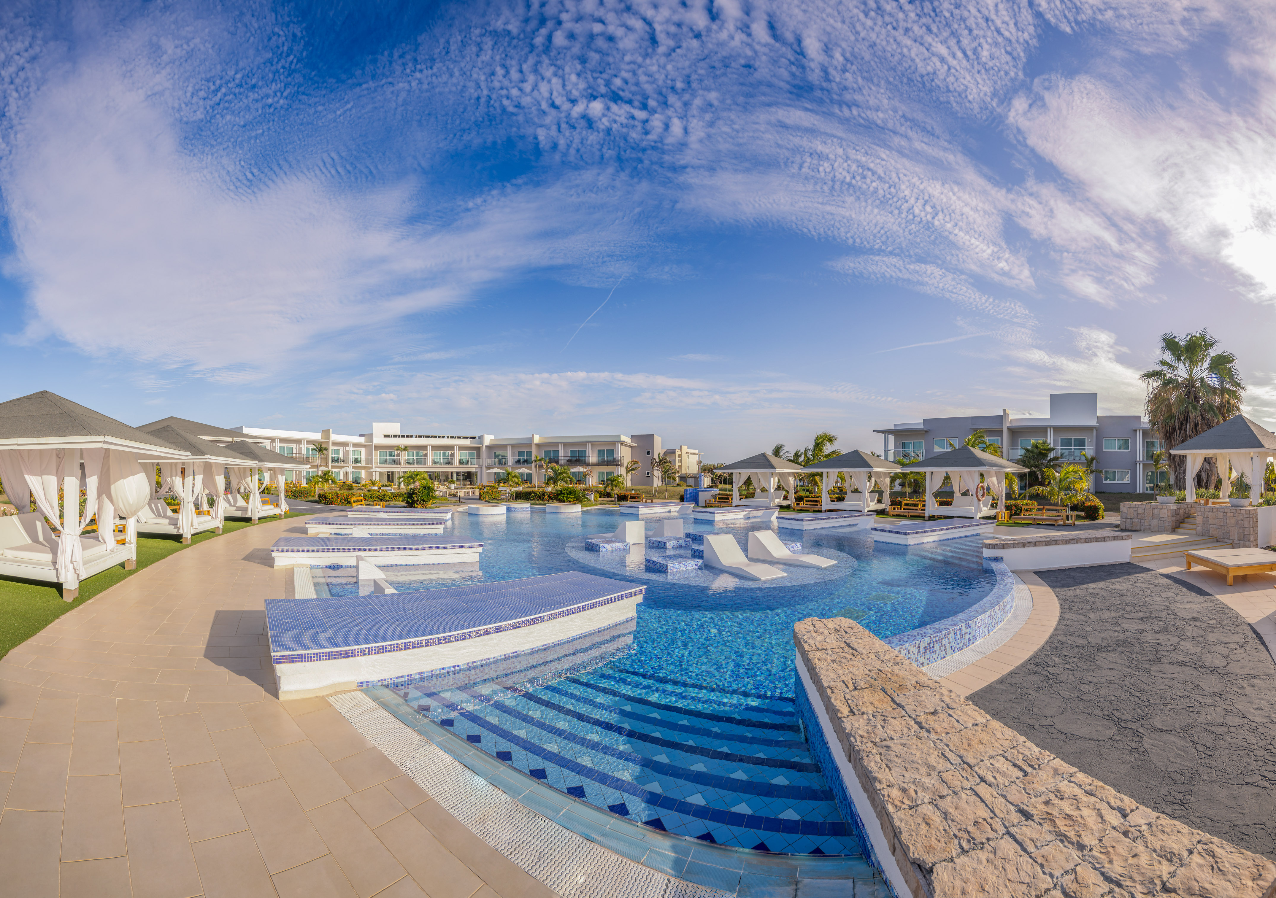 a pool with a deck and chairs in the middle of it