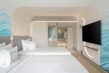 a room with two beds and a television