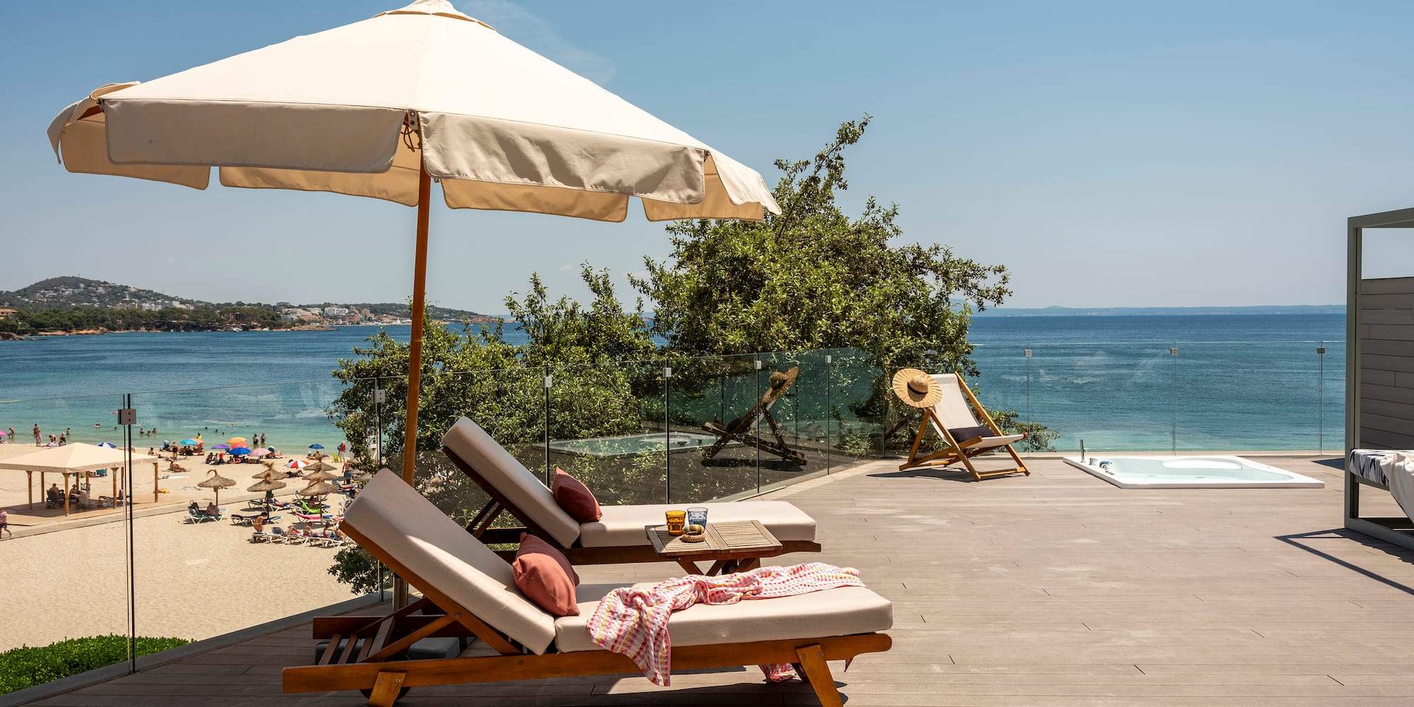 a deck with chairs and umbrella on a beach