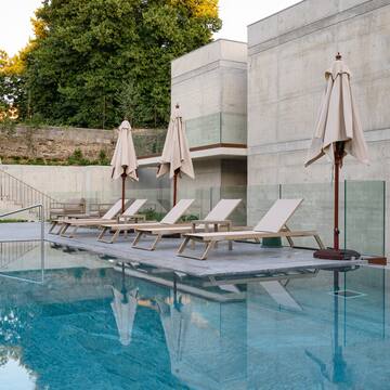 a pool with lounge chairs and umbrellas