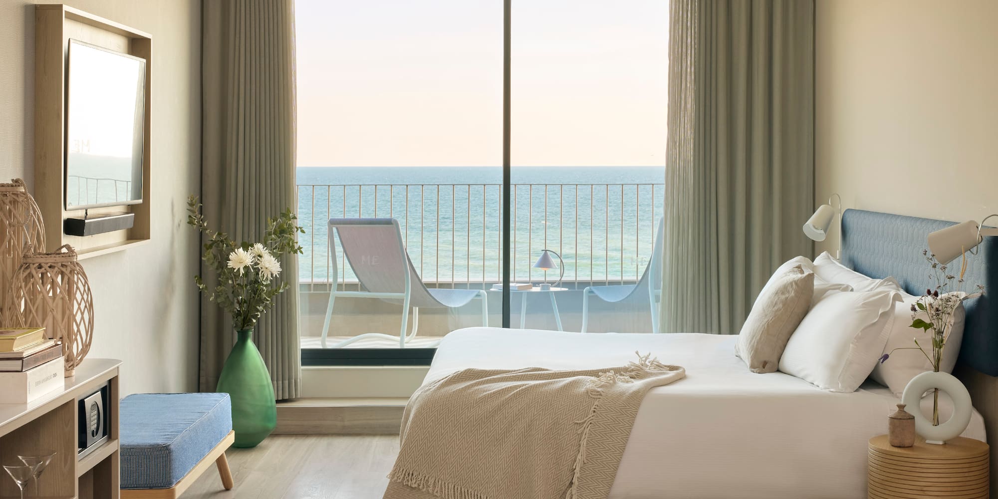 a bedroom with a large window overlooking the ocean