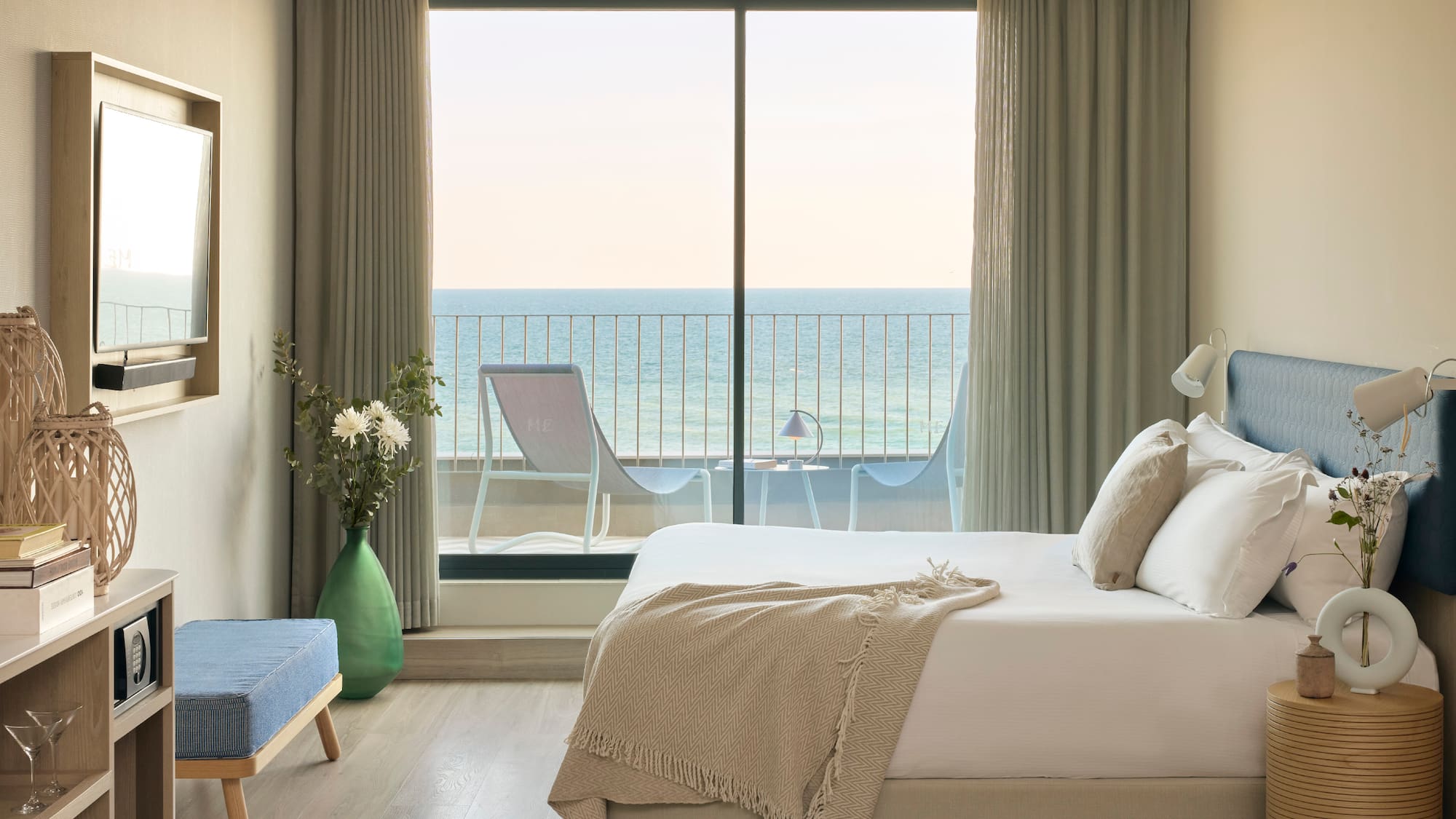 a bedroom with a large window overlooking the ocean
