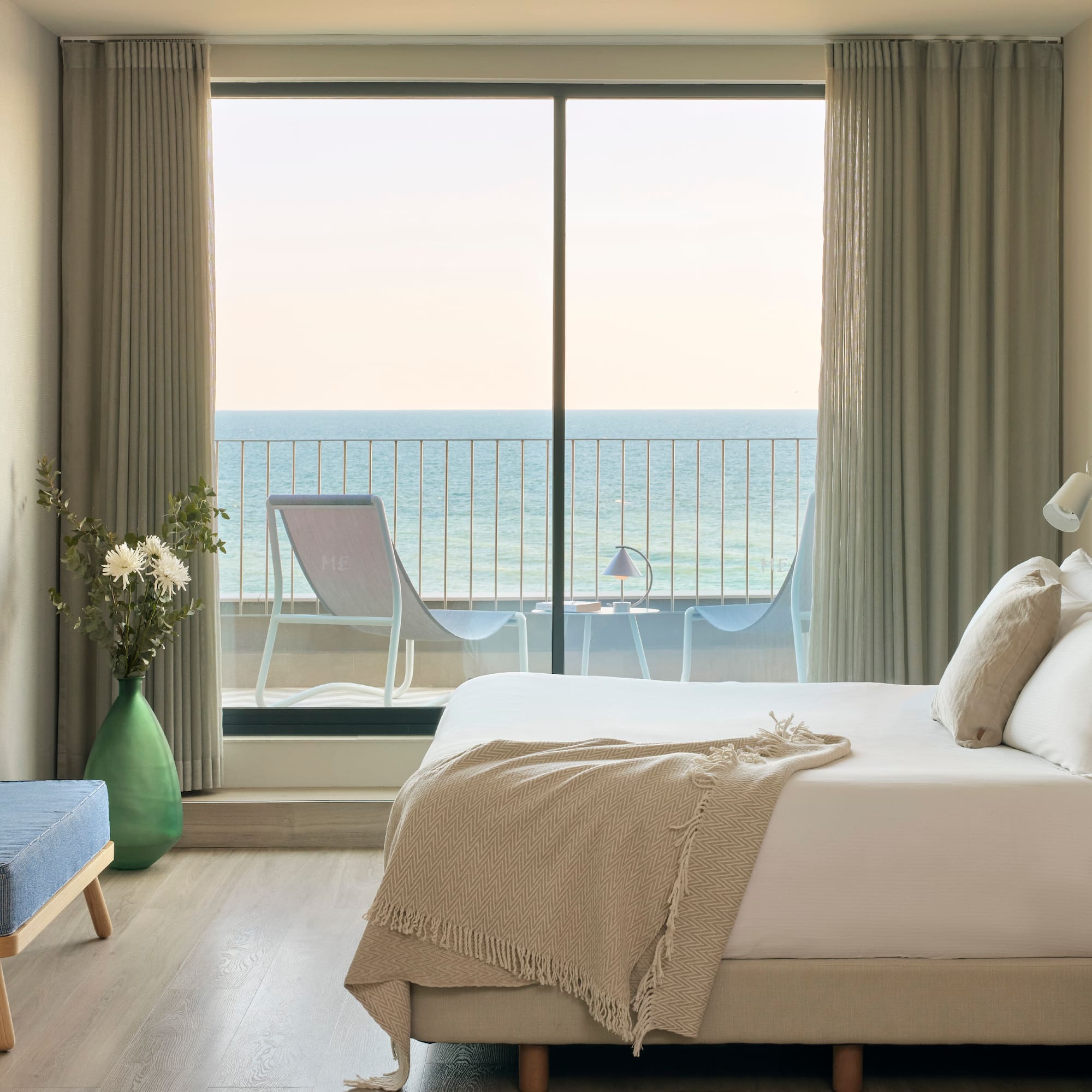a bedroom with a large window overlooking the ocean