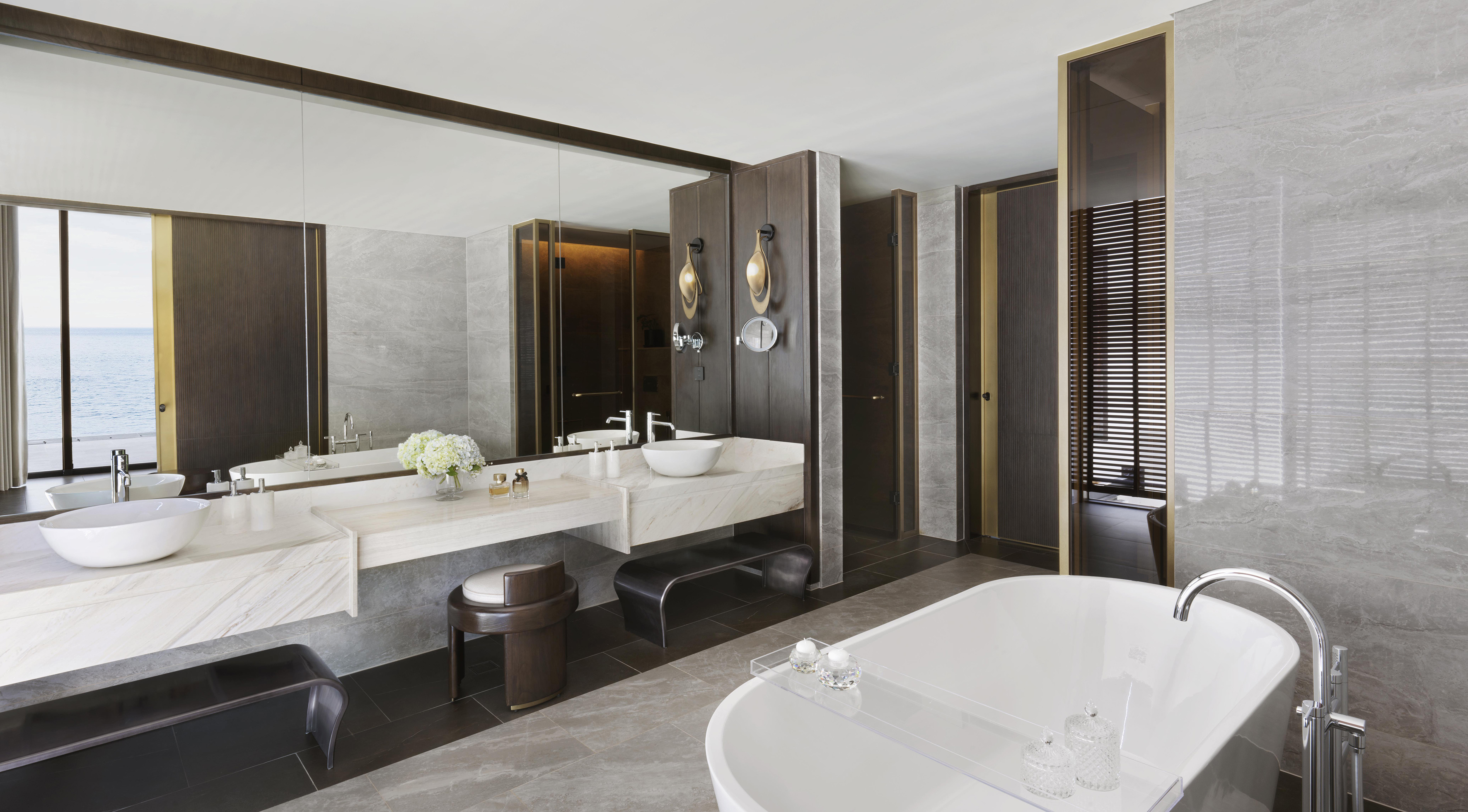 Luxury bathroom with ocean view, double vanity, and freestanding bathtub.