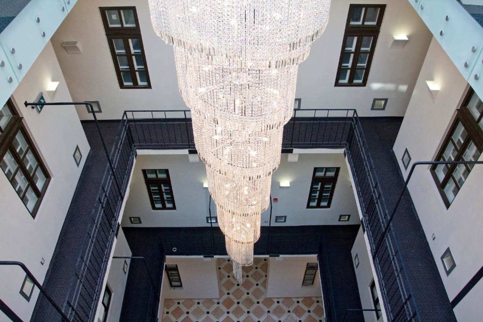 Grand crystal chandelier illuminating a multi-level hotel atrium.
