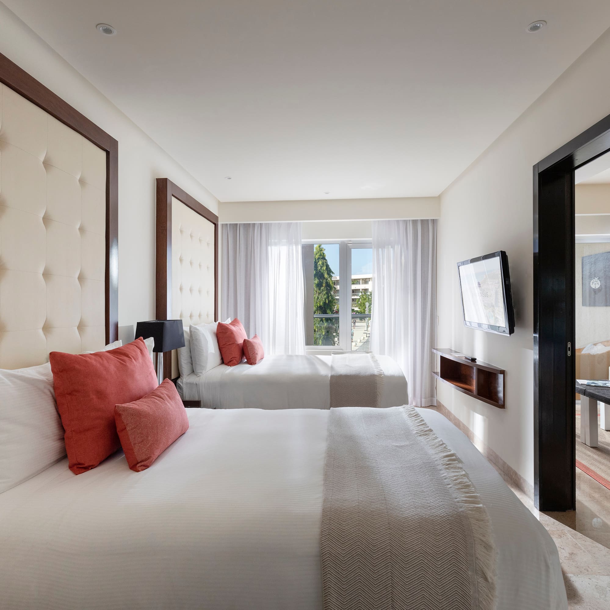 a room with two beds and a television