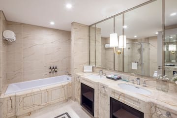 phòng tắm với mặt bàn đá cẩm thạch và bồn tắm