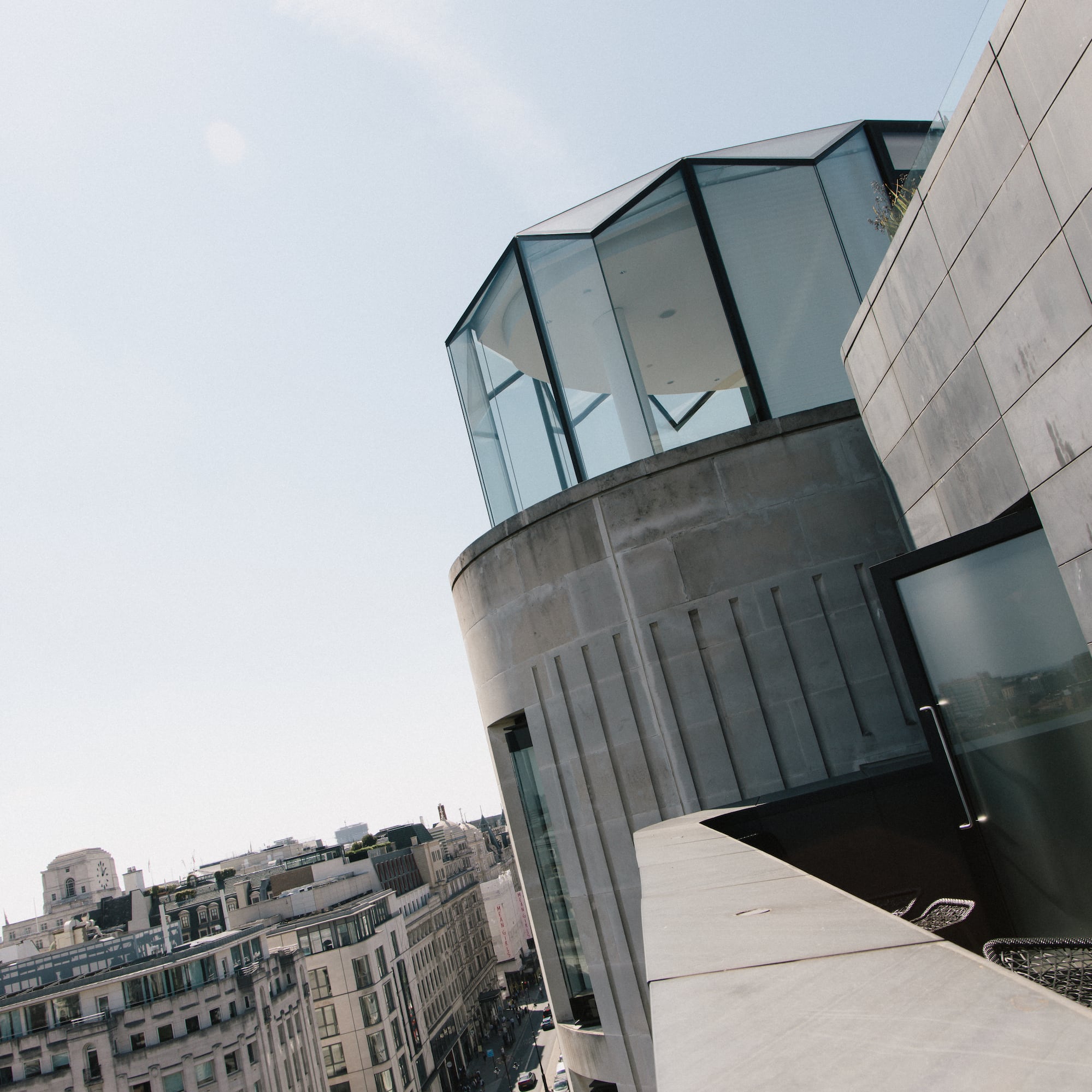 London rooftop view: modern glass building, street with double-decker bus.