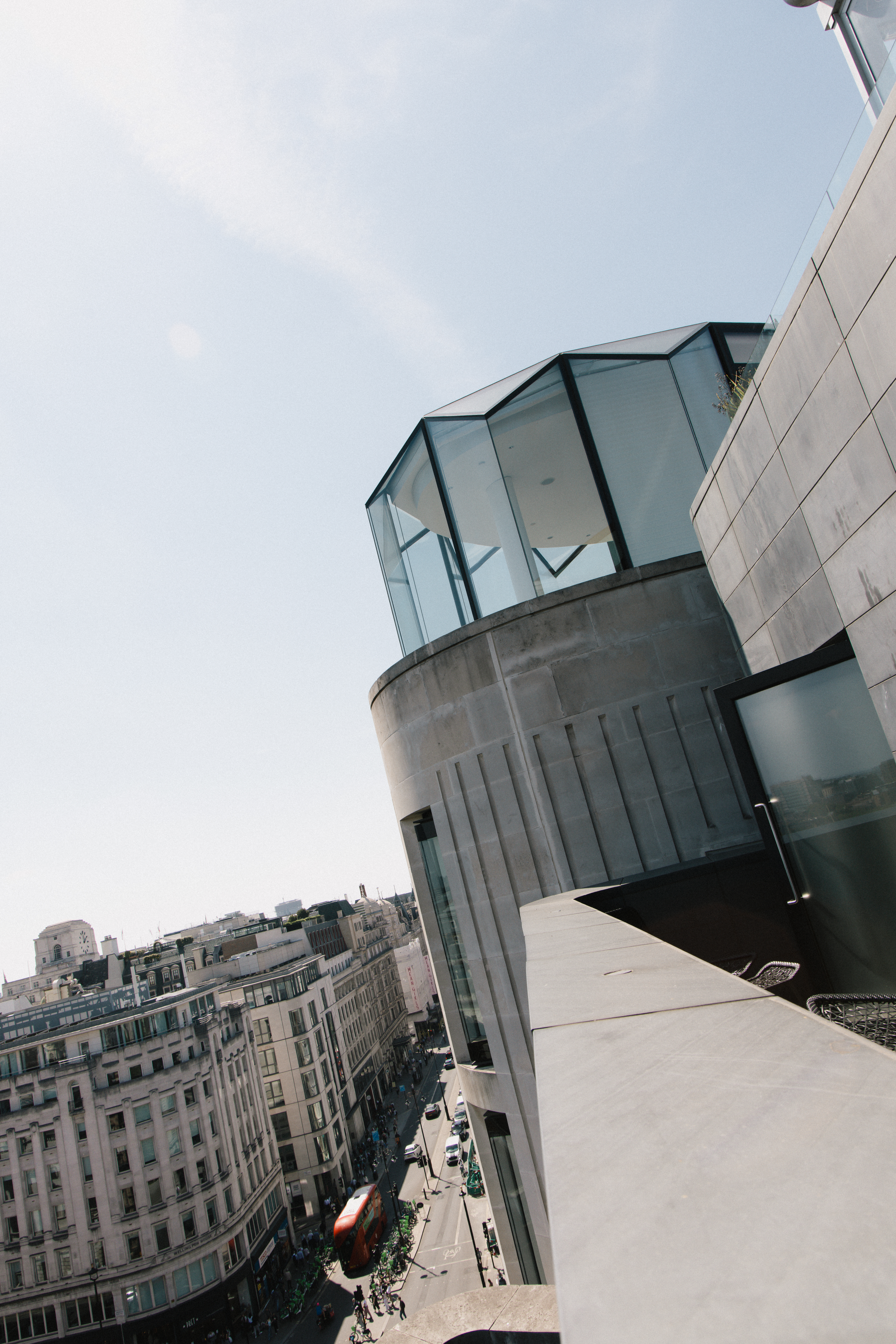 London rooftop view: modern glass building, street with double-decker bus.
