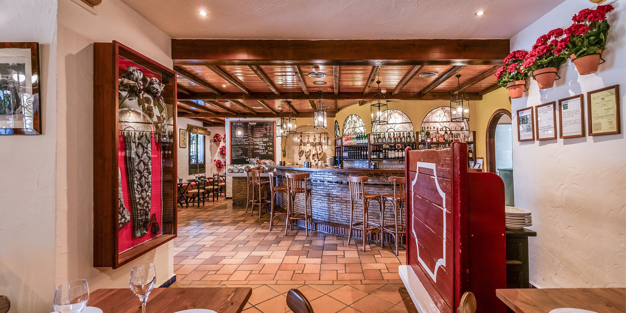 a restaurant with a bar and wine glasses