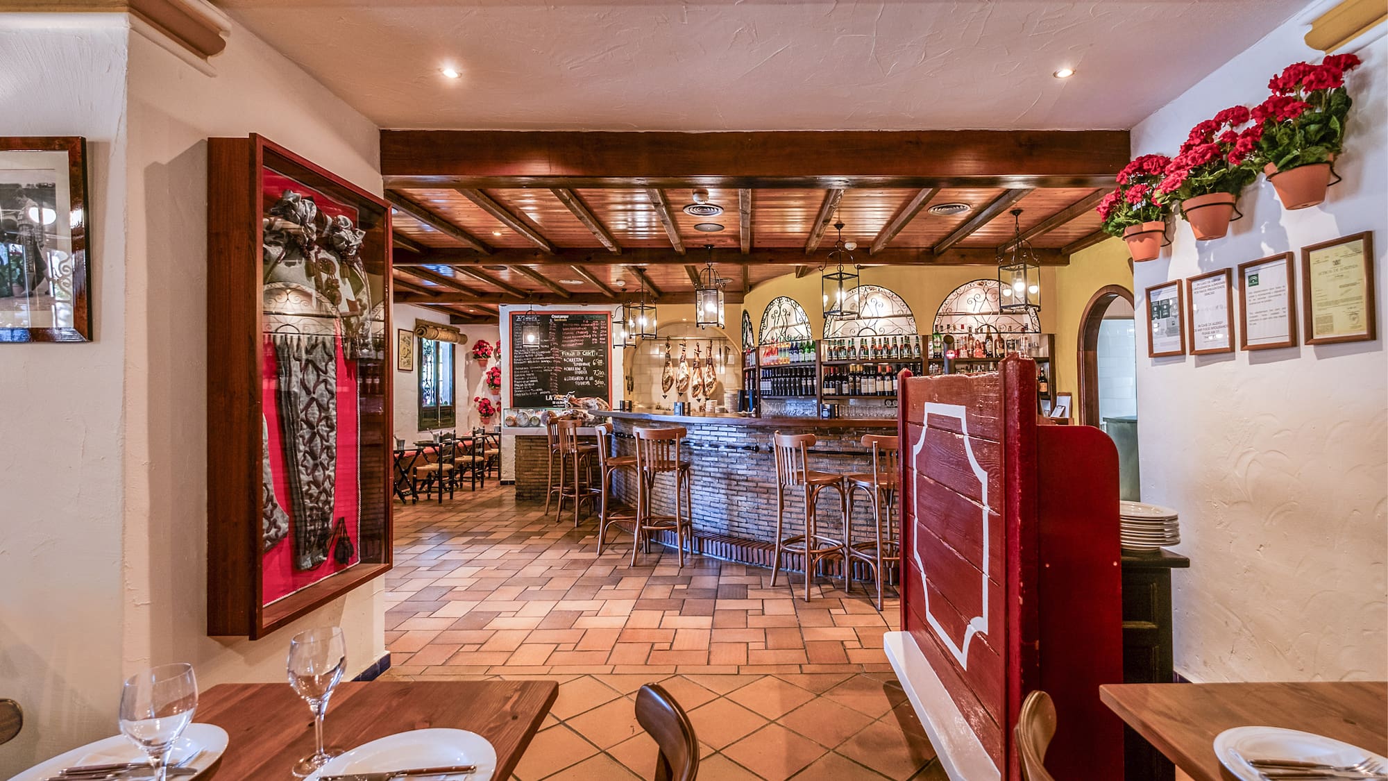 a restaurant with a bar and wine glasses