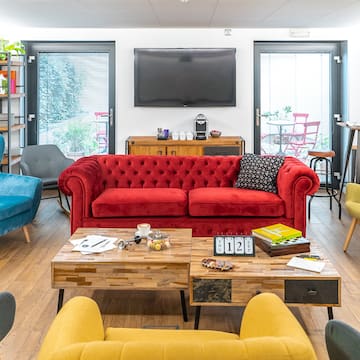 a room with a red couch and blue chairs