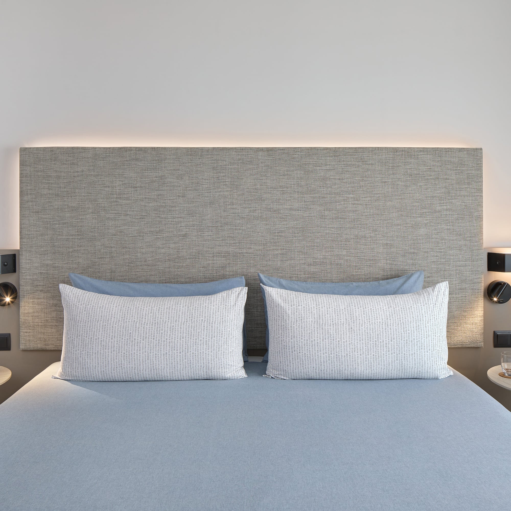 a bed with a headboard and a lamp