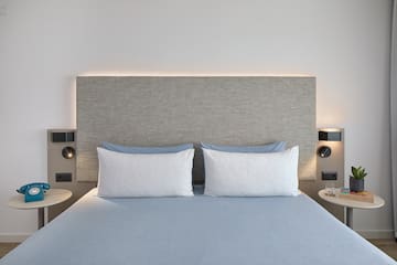 a bed with a headboard and a lamp