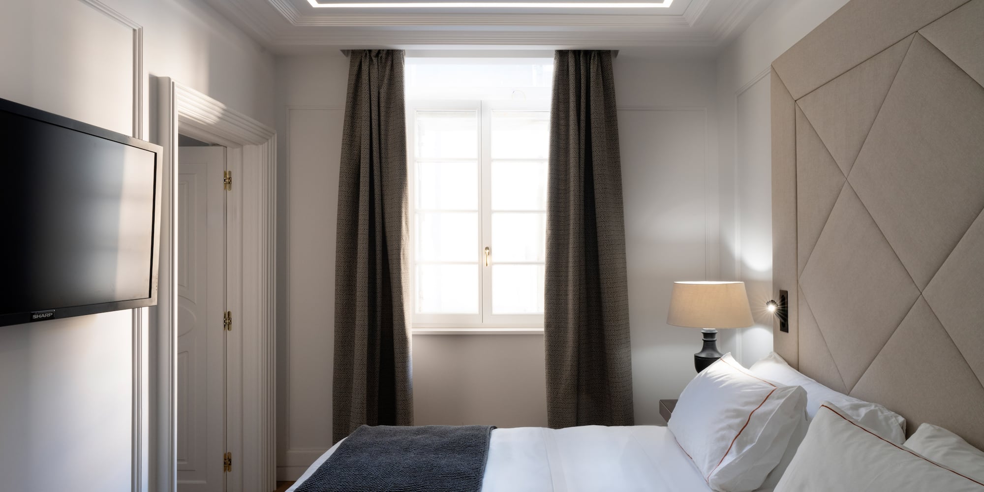 a bed with a lamp and a window