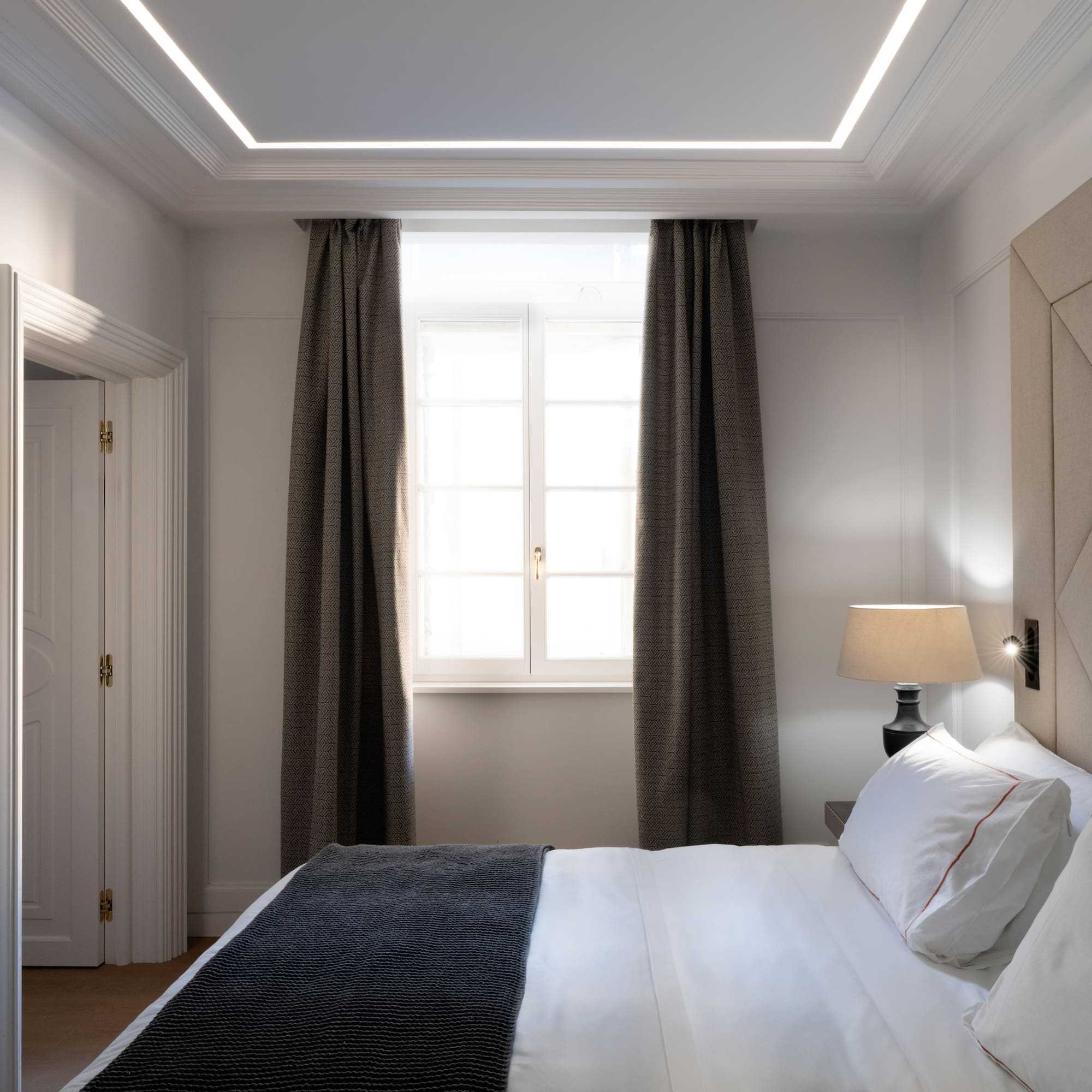 a bed with a lamp and a window