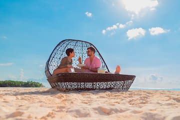 a man and woman sitting on a beach chair