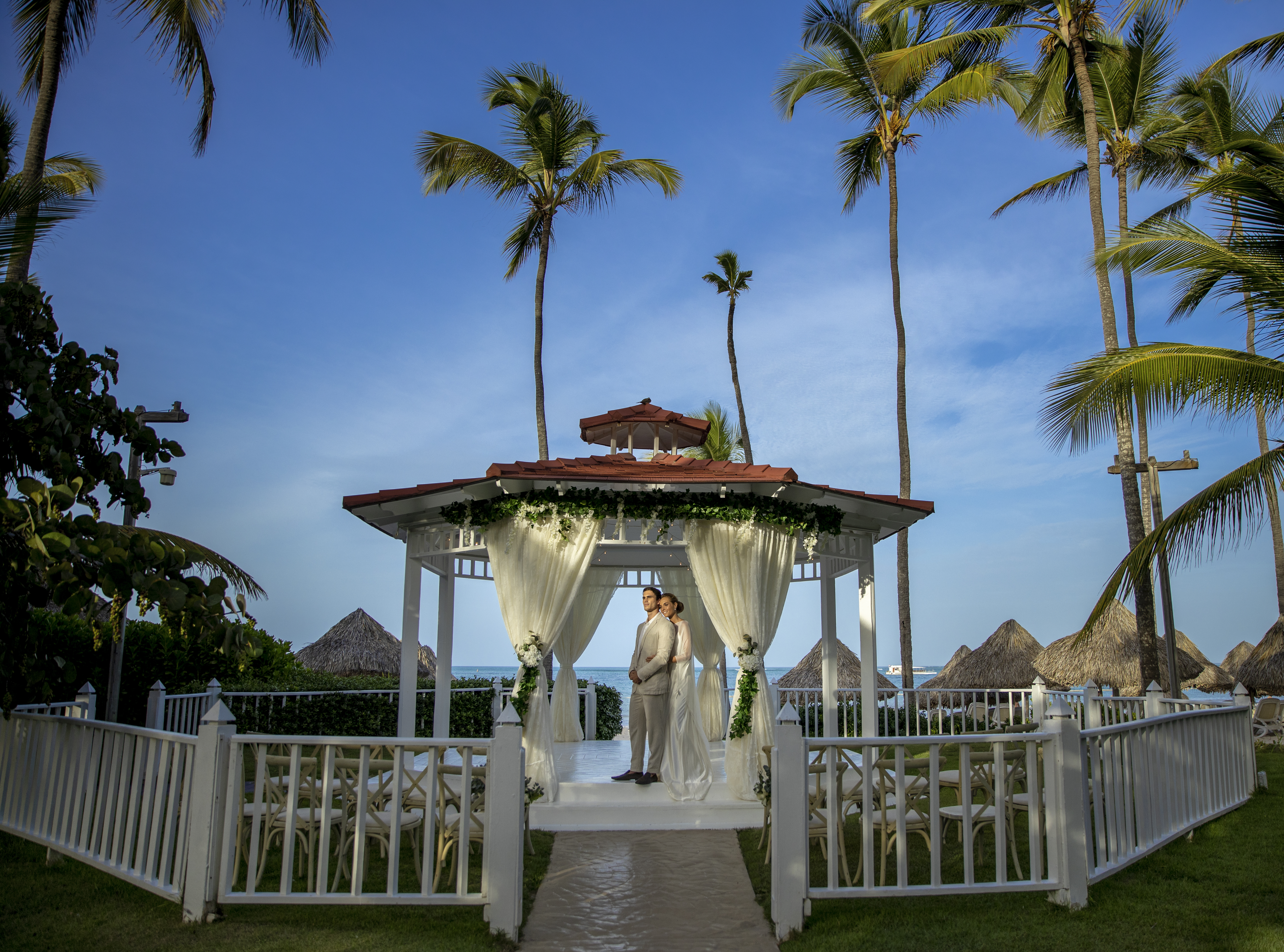 a man and woman standing under a gazebo