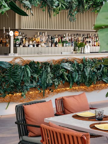 a table and chairs with plants on the wall