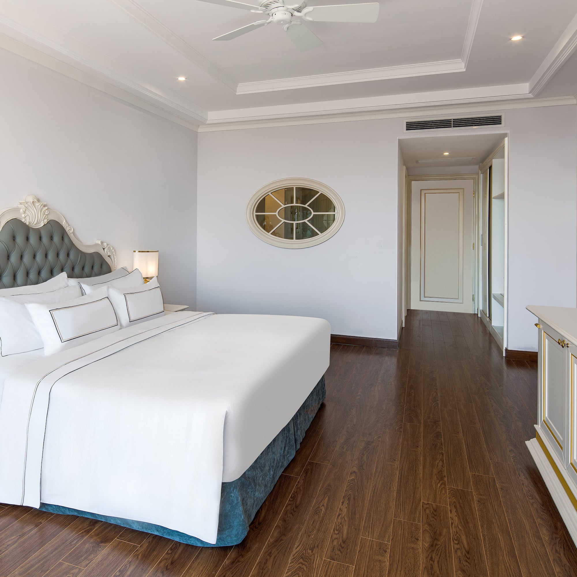 a bedroom with a white bed and wood floor