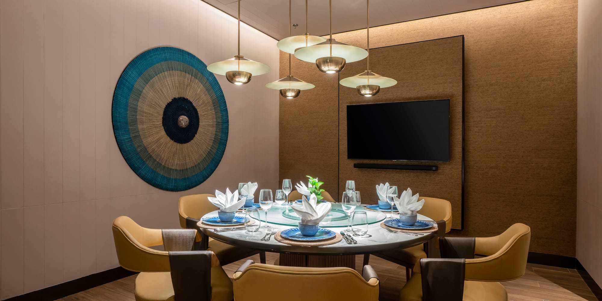 a dining room with a table set with chairs and a television