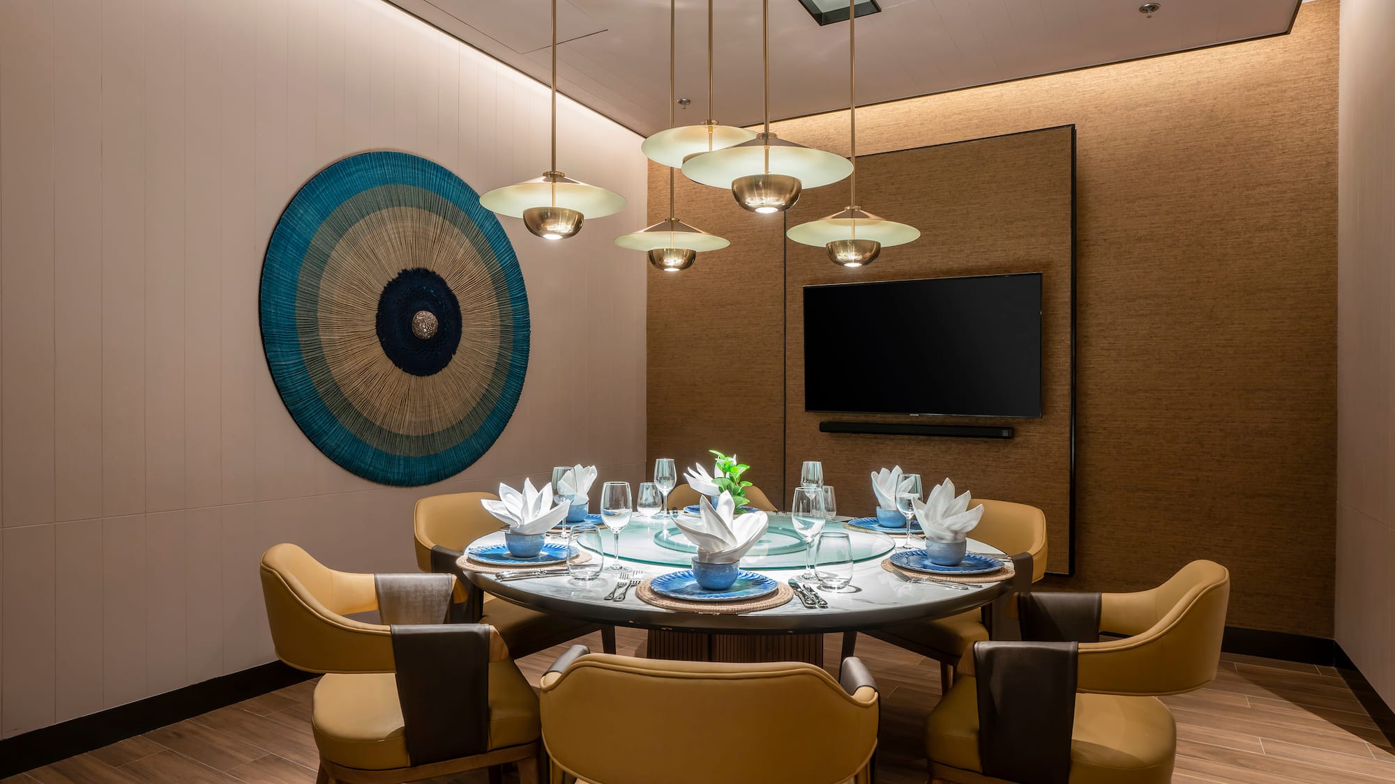 a dining room with a table set with chairs and a television