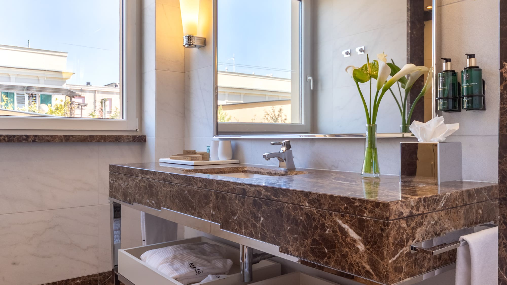 a bathroom with a marble countertop and a large mirror