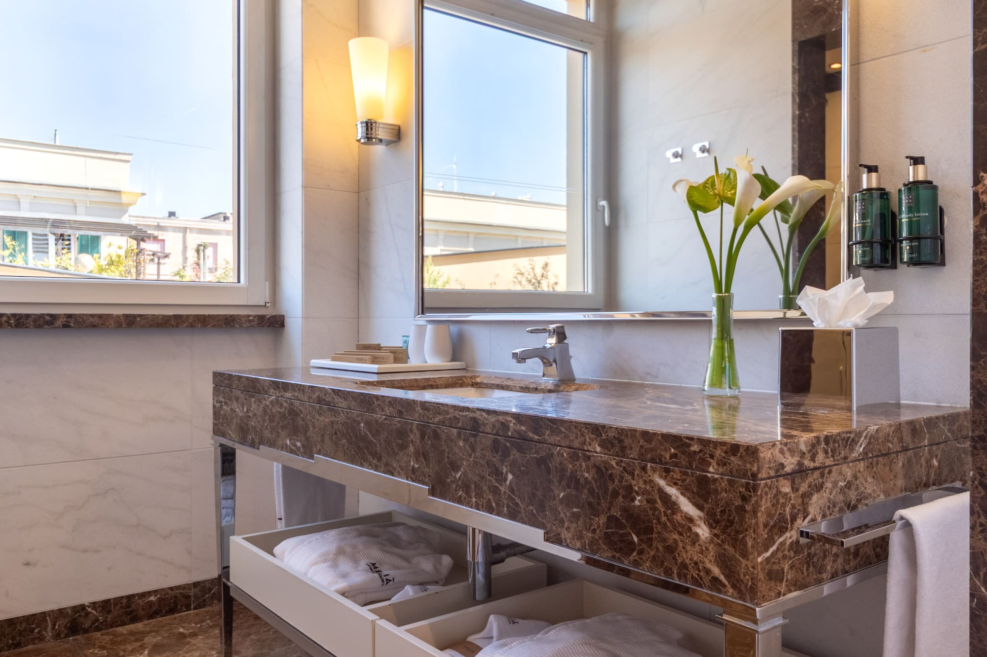 a bathroom with a marble countertop and a large mirror