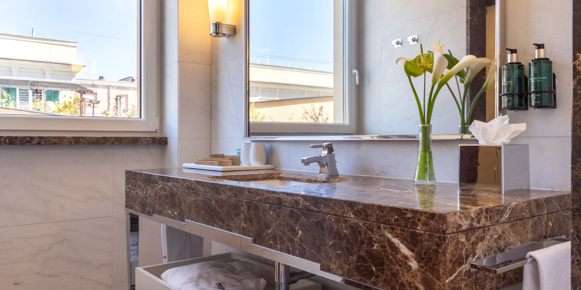 a bathroom with a marble countertop and a large mirror