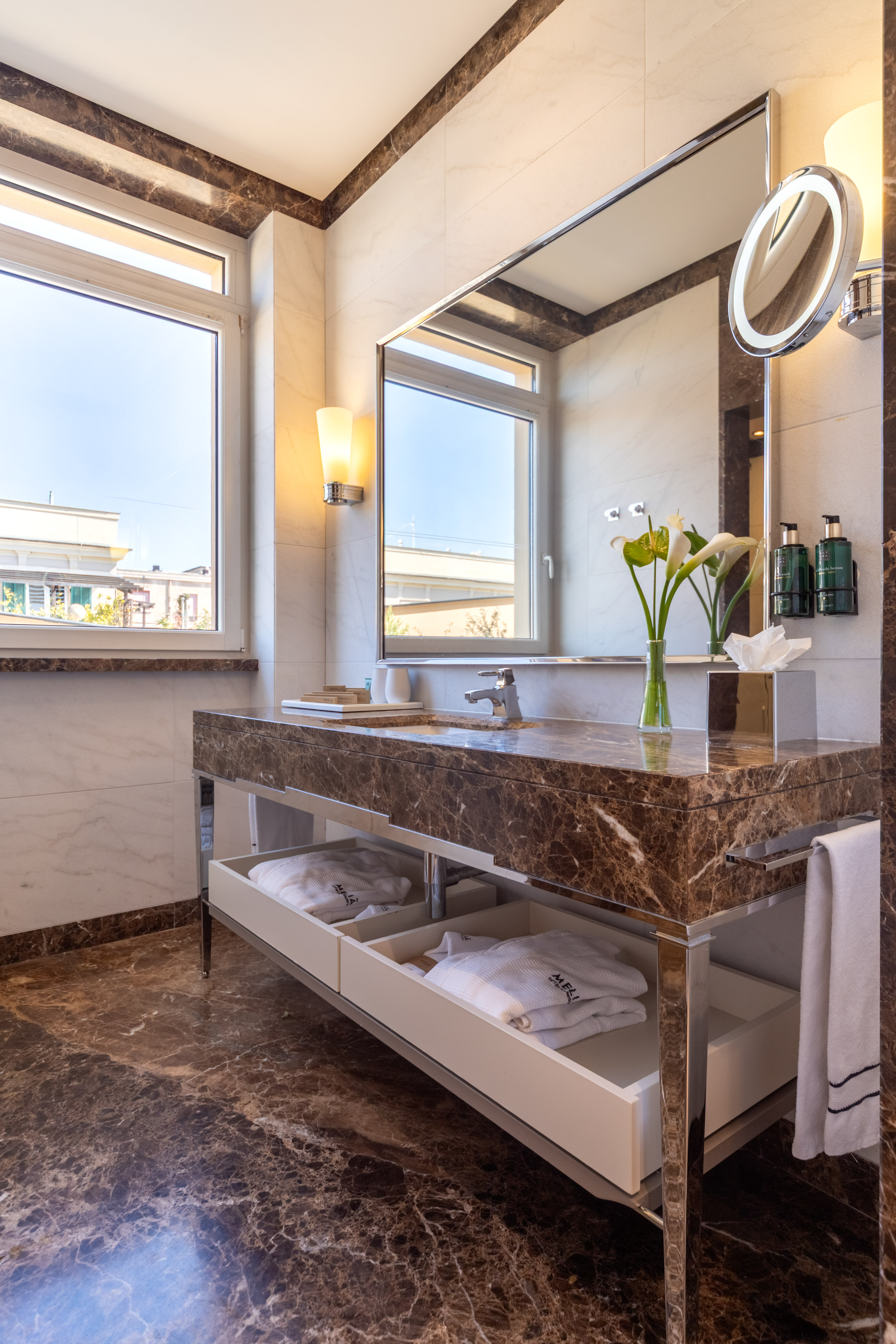 Modern luxury bathroom with marble vanity, mirror, window, and bathrobes. - Junior Suite met Terras - Meliá Genova, Genua