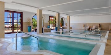 a large indoor pool with stairs and railings