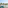 Balcony with turquoise chairs, table, sunny view of green trees and buildings.
