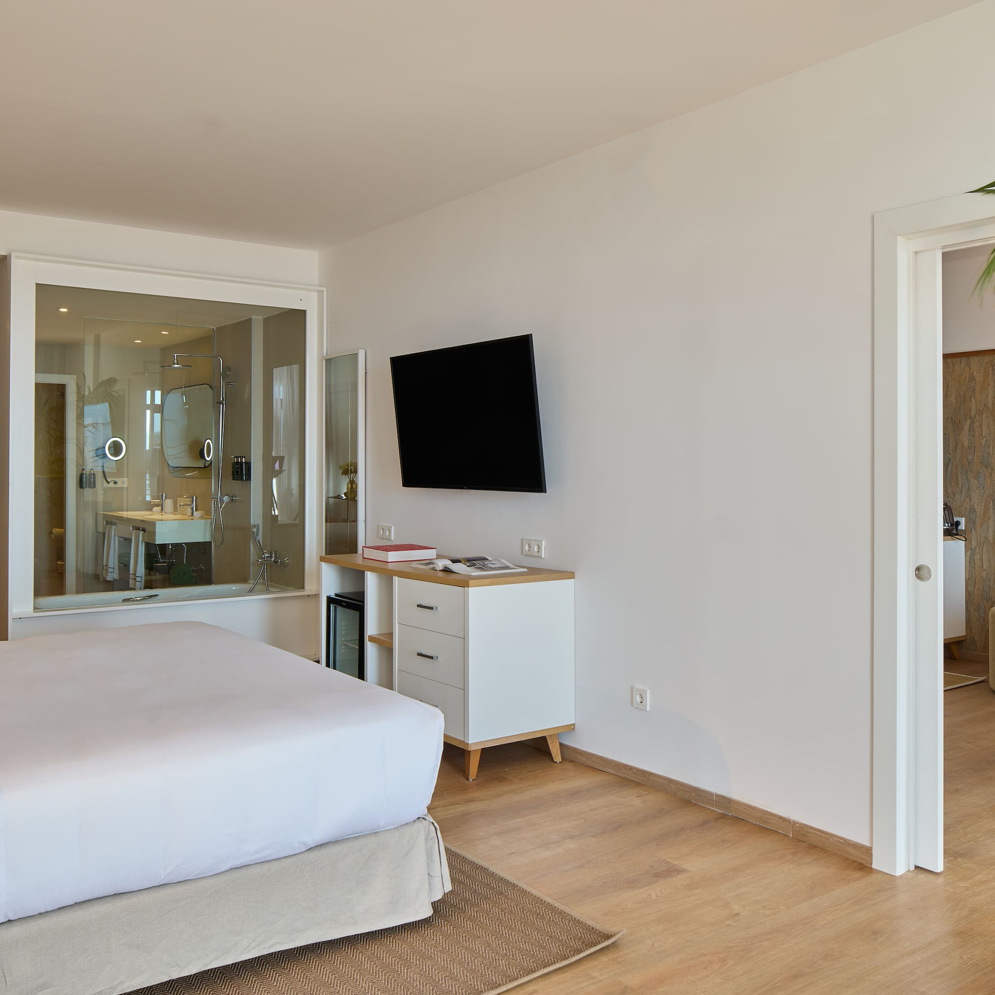 a bedroom with a tv and a wood floor