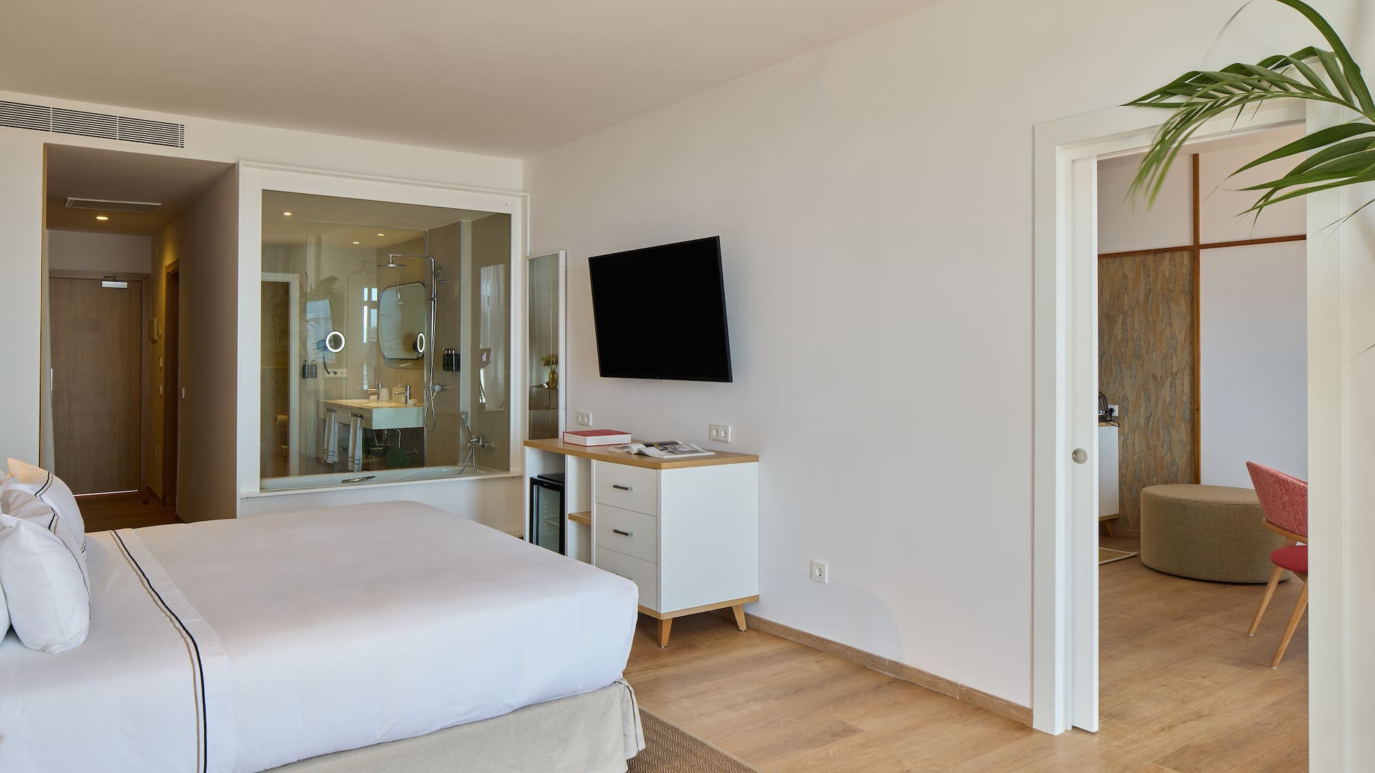 a bedroom with a tv and a wood floor