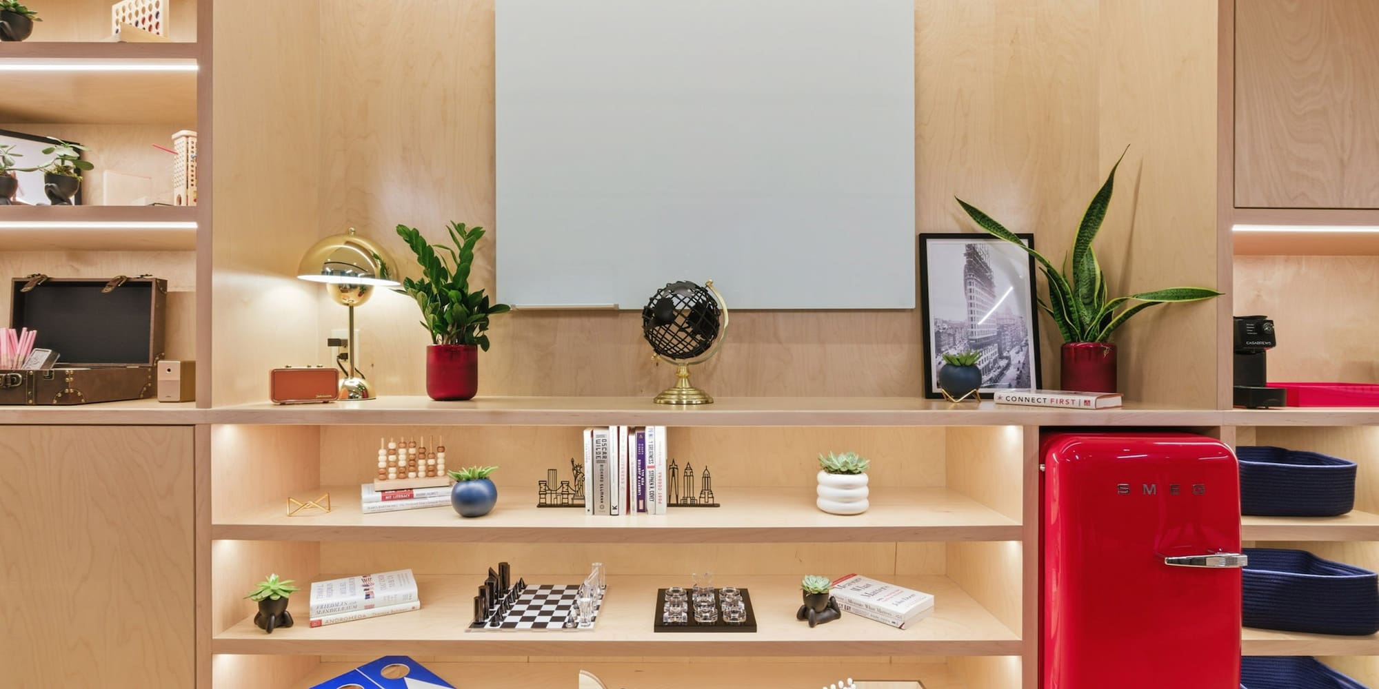 a shelf with books and a red refrigerator