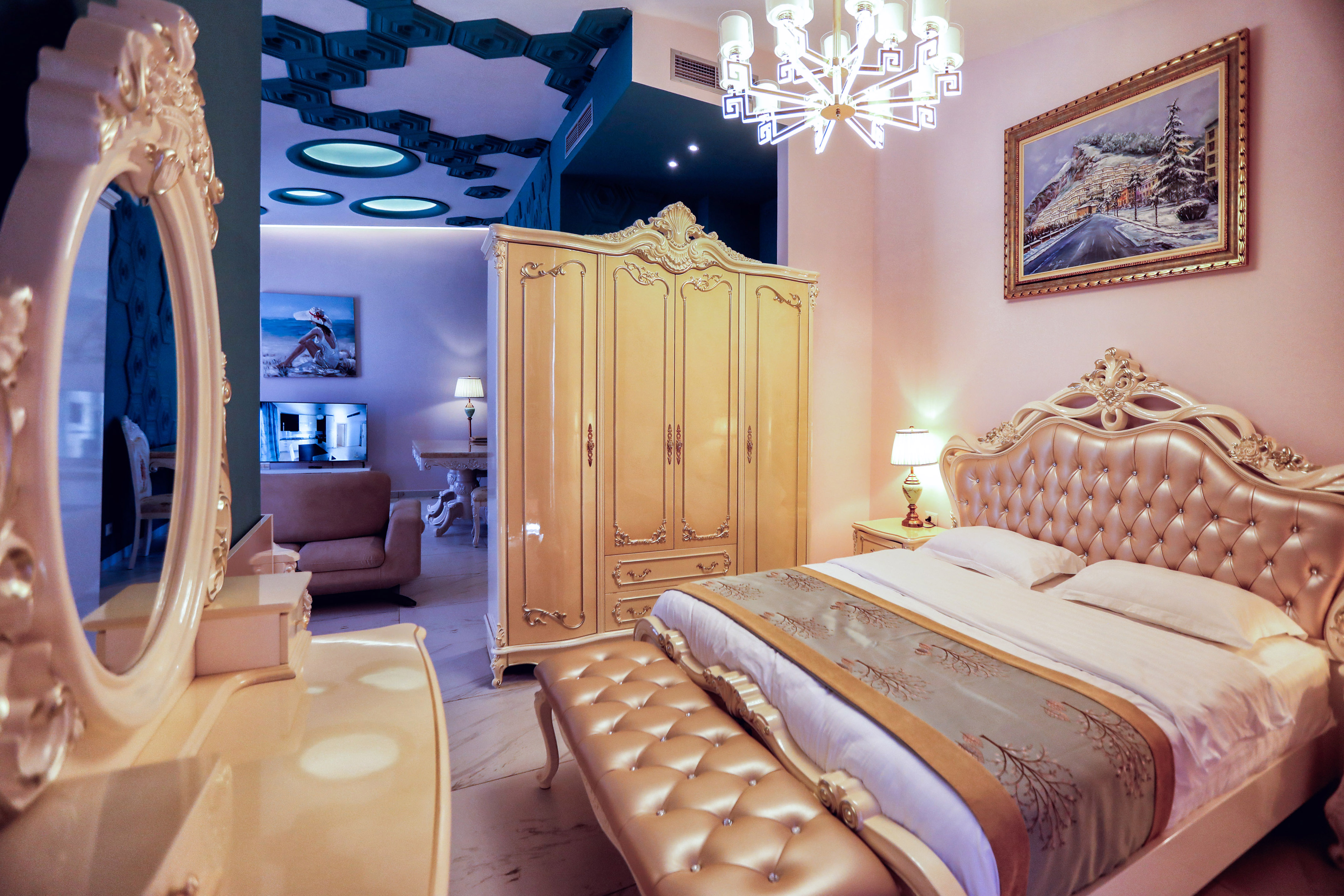 Ornate luxury hotel bedroom with gilded tufted bed, wardrobe, and elegant furniture.