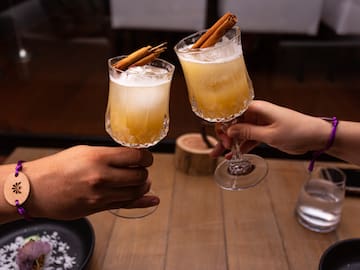 a pair of hands holding glasses with drinks