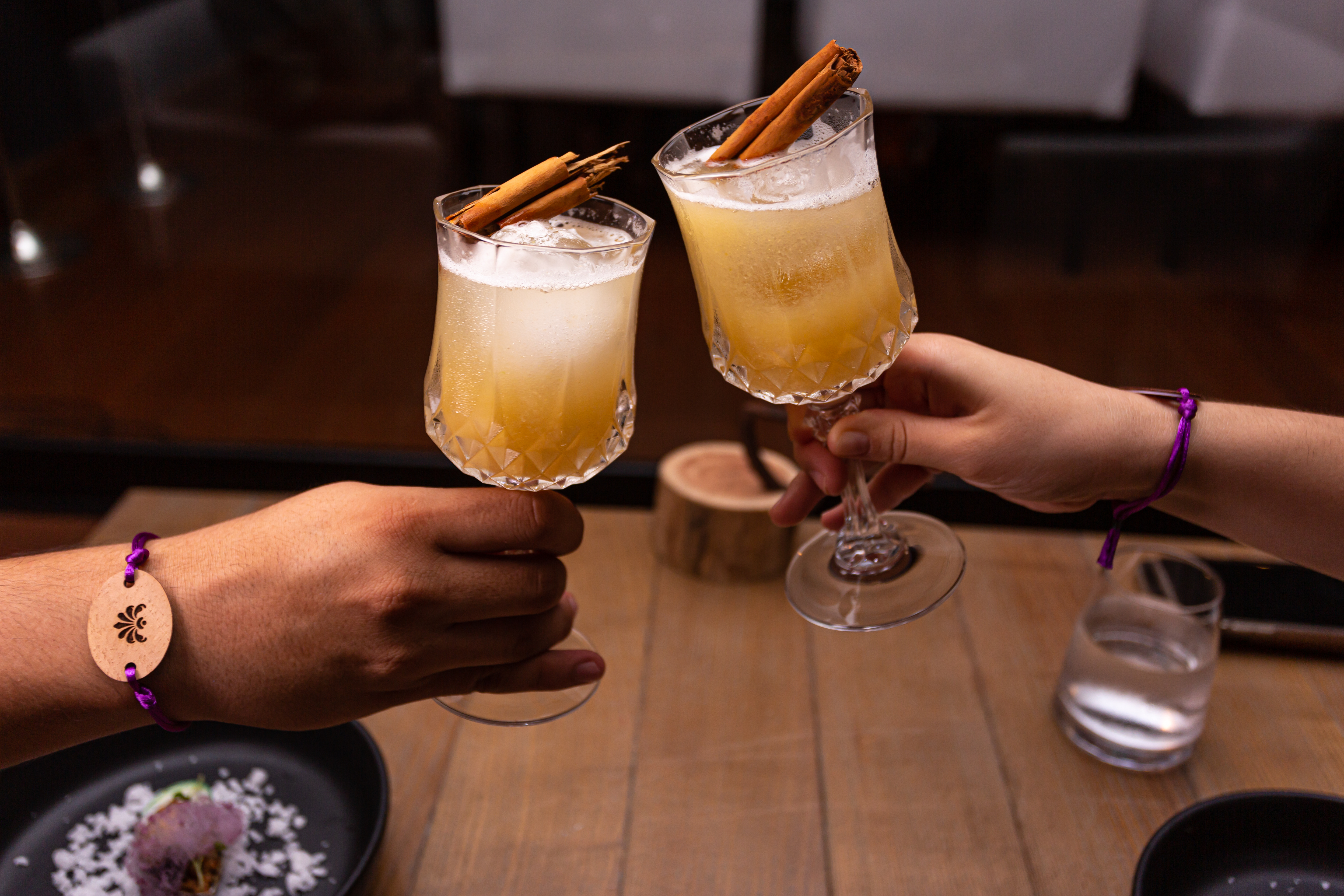 a pair of hands holding glasses with drinks