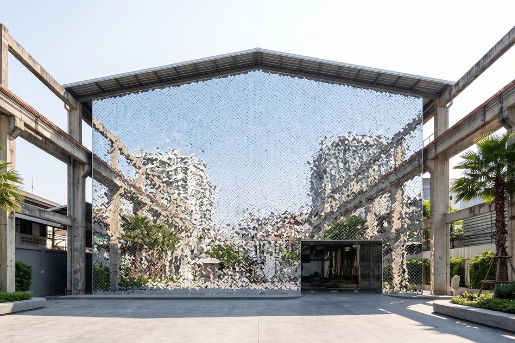 Fachada de edificio moderno con espejos pixelados, vigas de hormigón y palmeras.