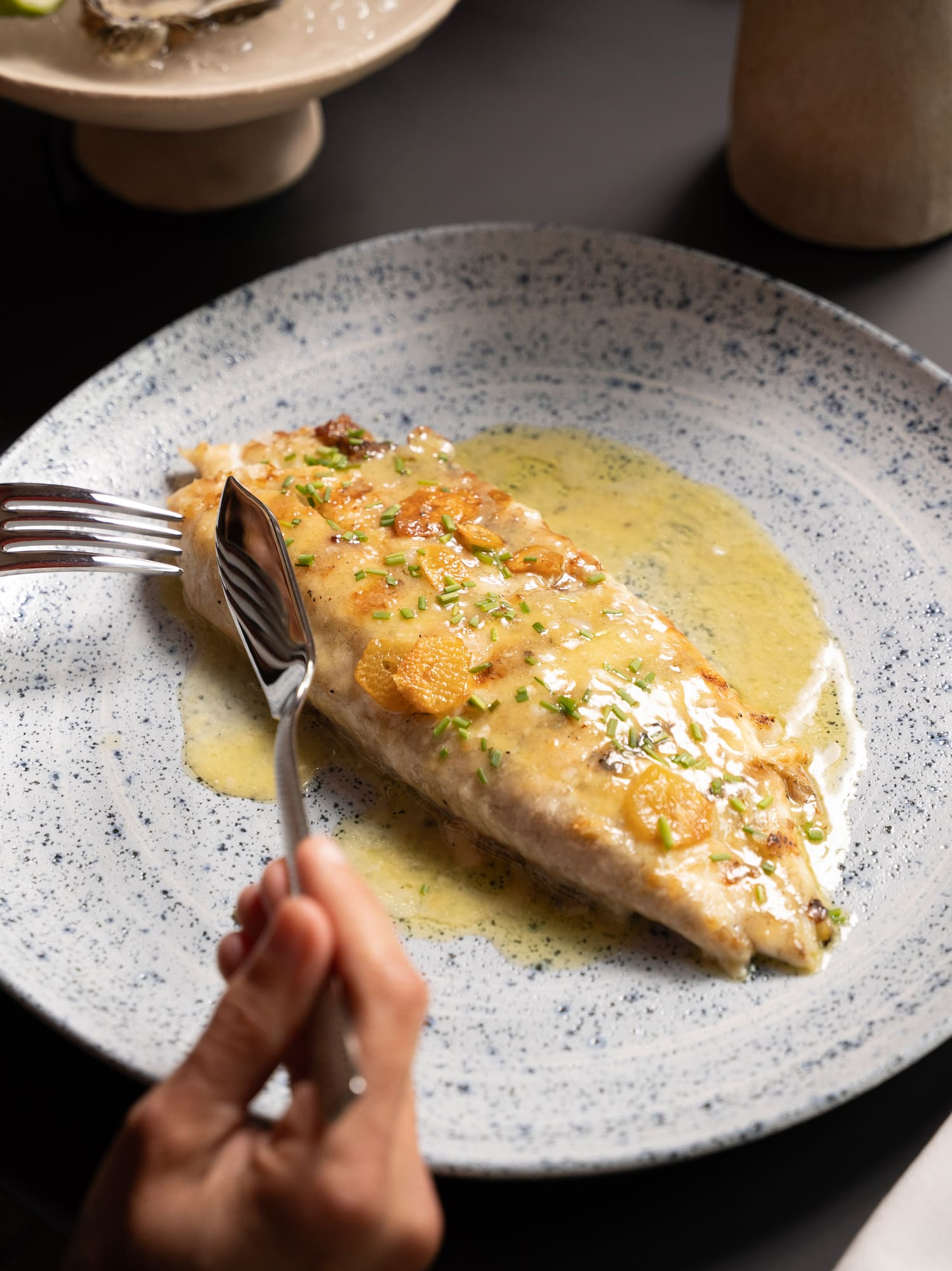 a person eating a fish with a fork and knife