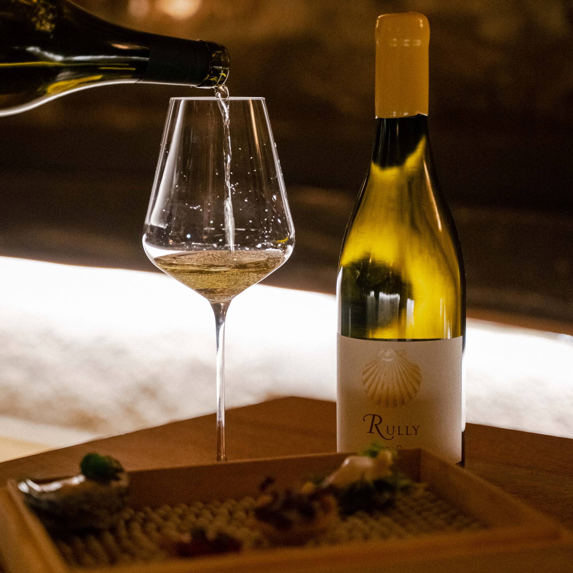 a bottle of wine being poured into a glass