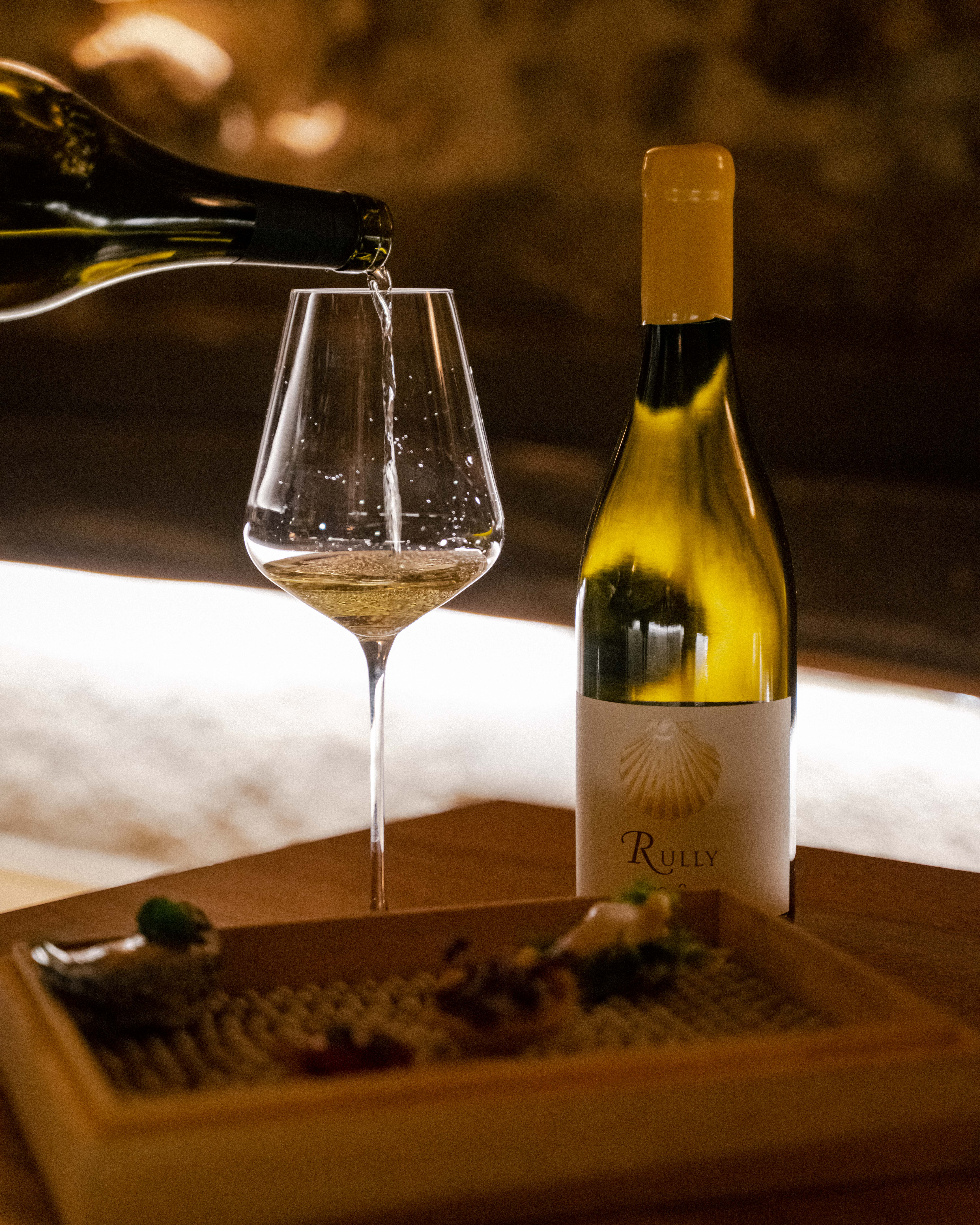 a bottle of wine being poured into a glass