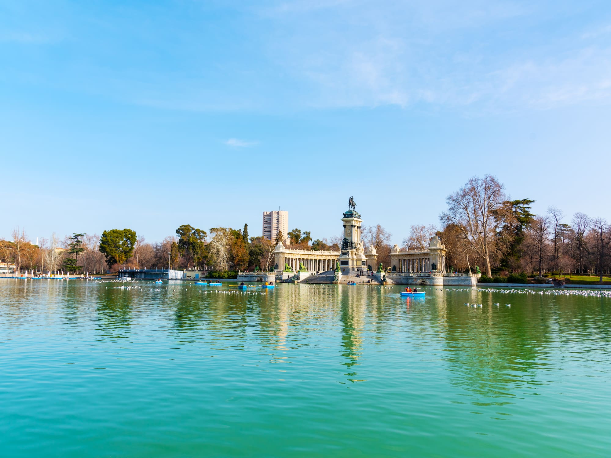 A body of water featuring a structure and several boats.