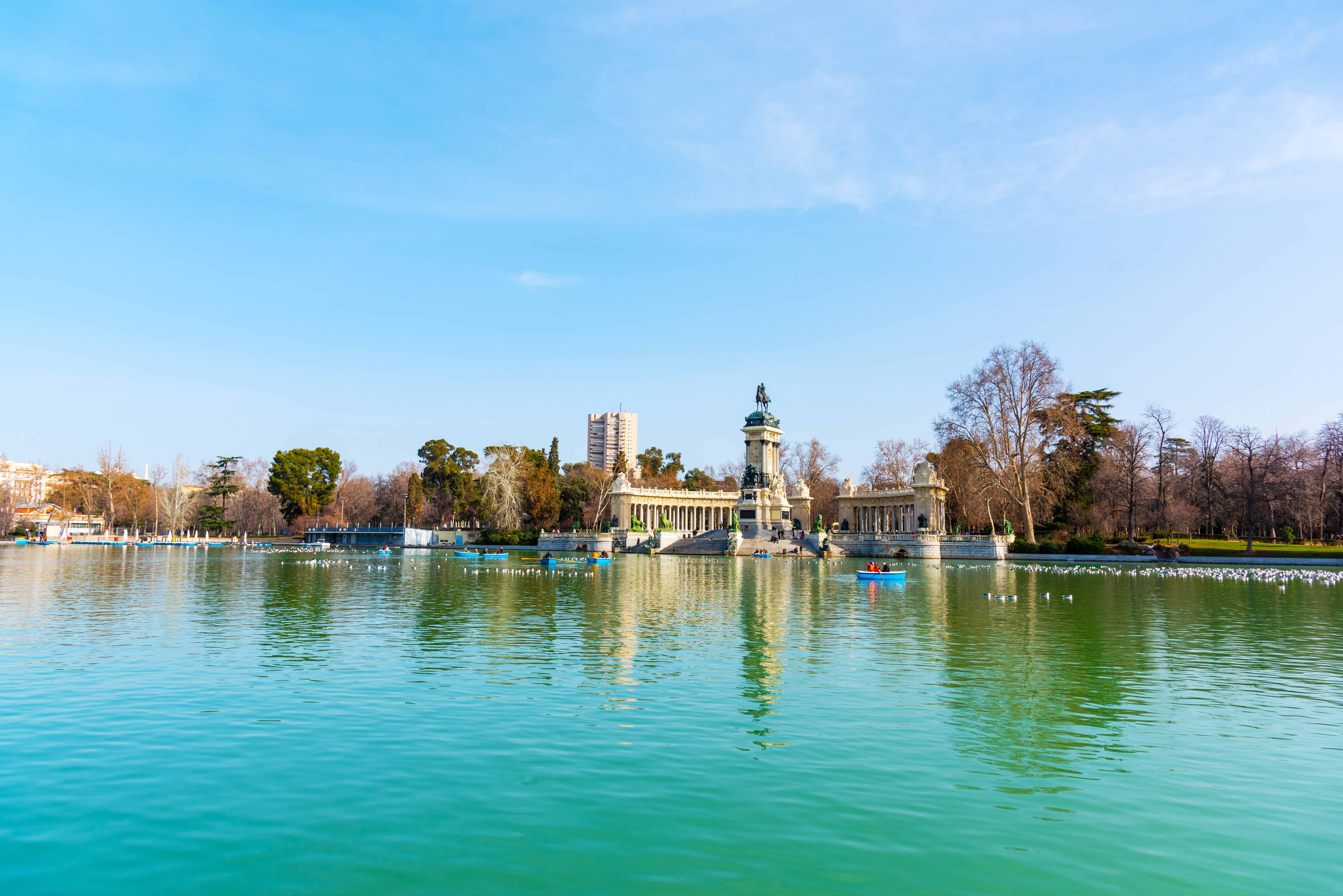 a lake surrounded by a building and several boats