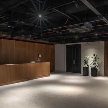 a room with a reception desk and plants