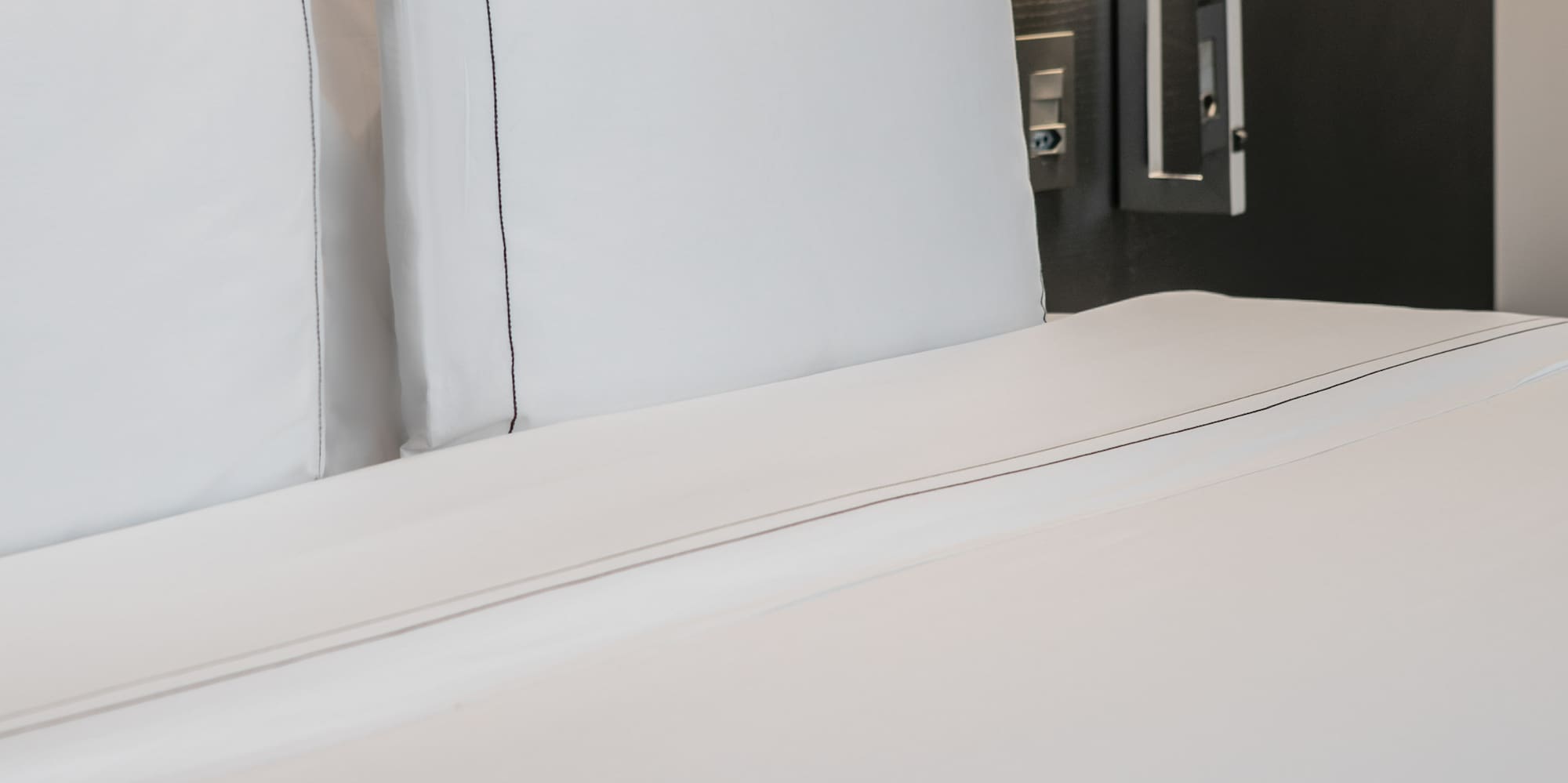 a bed with white sheets and a lamp